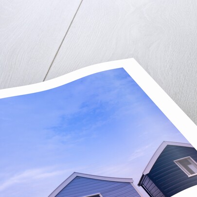 Beach huts in a row against sky by Assaf Frank